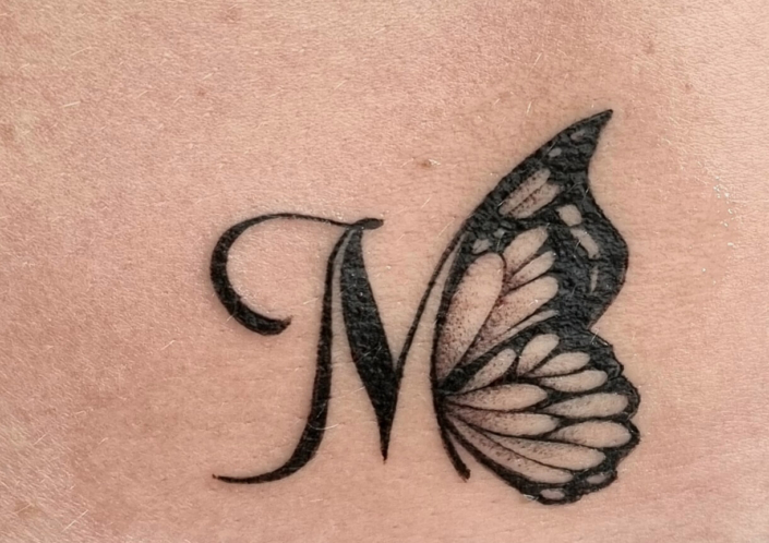 Tatuaje pequeño Letra mariposa mujer